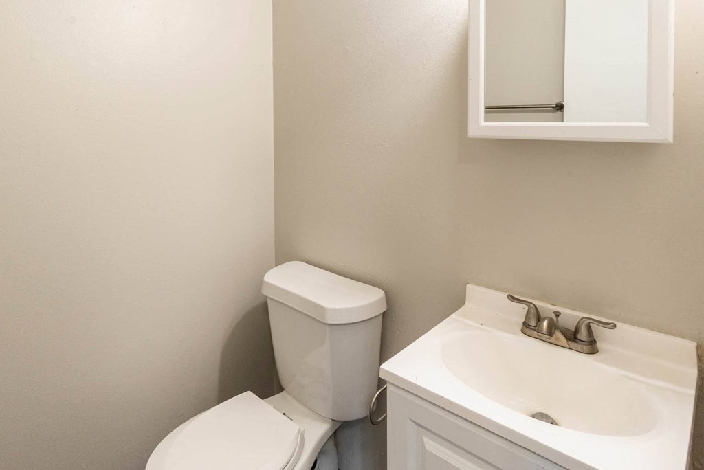 a bathroom with a sink toilet and mirror