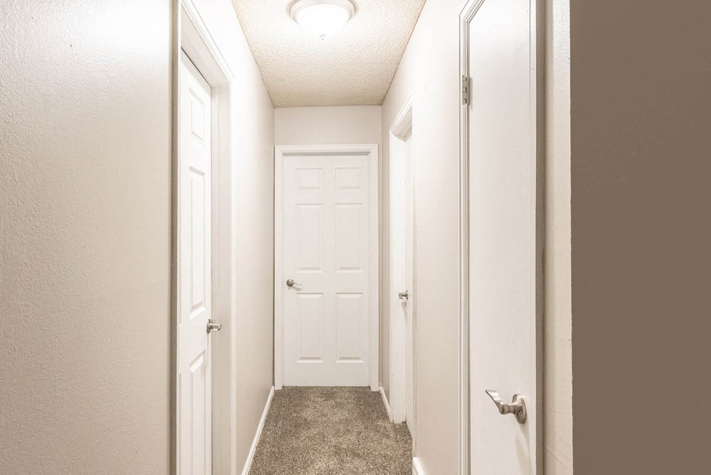 a hallway with two doors and a carpeted floor