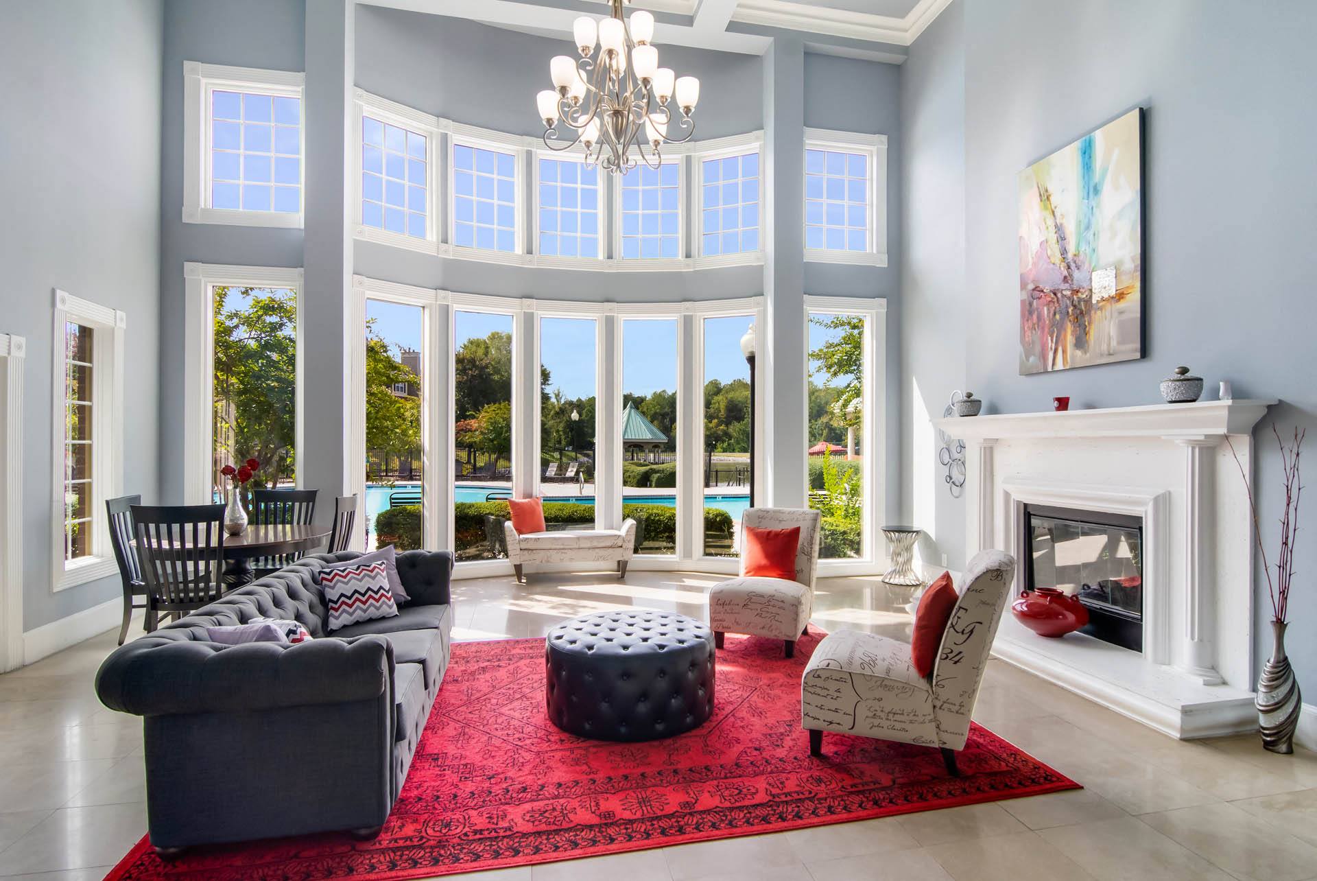 a living room with large windows and a red rug