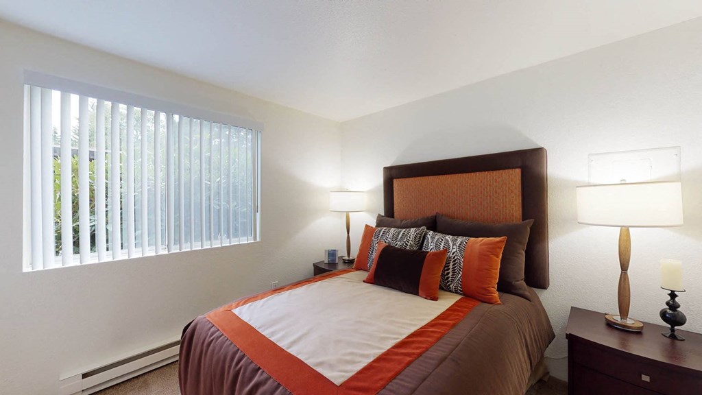Bedroom with cozy bed and window at North Creek Apartments, Everett, WA