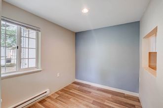 a bedroom with a large window and hardwood floors - Photo Gallery 3