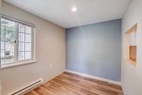 a bedroom with a large window and hardwood floors at Glen at North Creek, Everett, Washington 