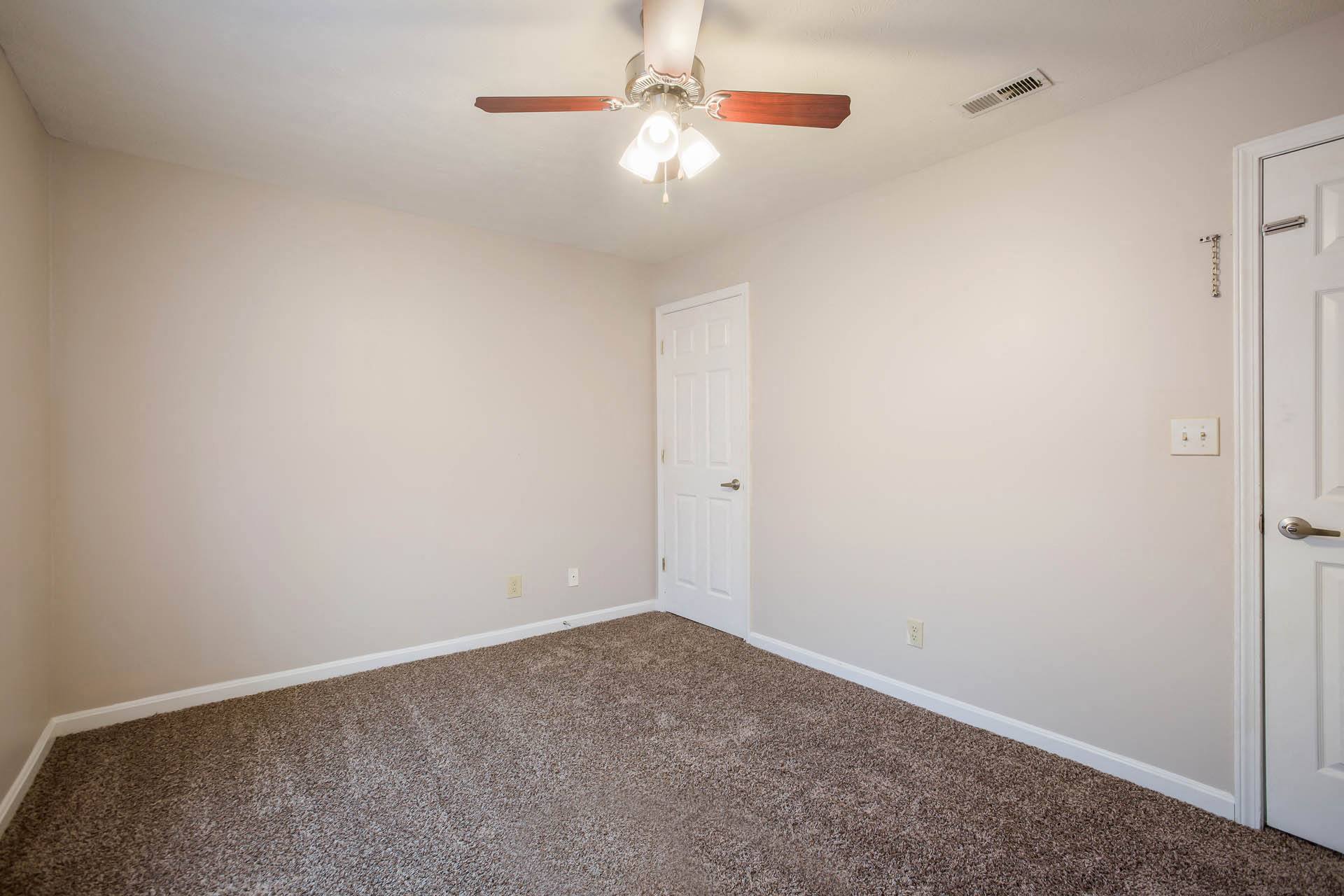 a bedroom with carpet and a ceiling fan