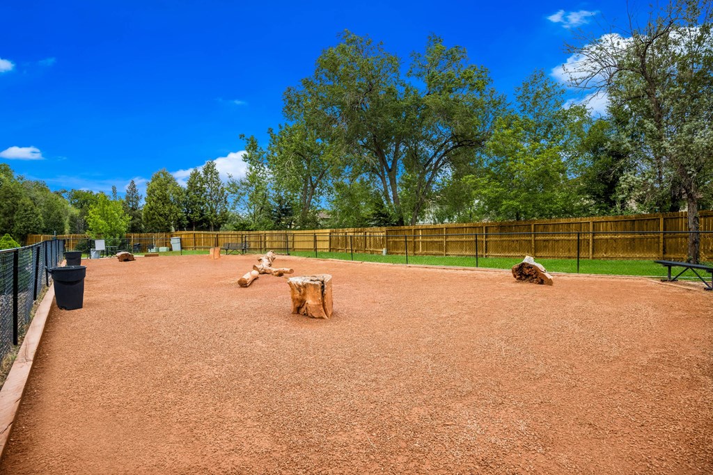 a dog park with trees and a blue sky in the background at Broadmoor Springs, Colorado Springs, CO, 80906