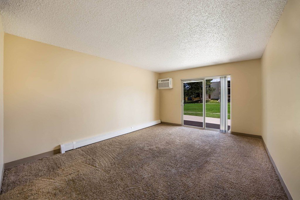an empty room with a glass door leading to a yard at Broadmoor Springs, Colorado Springs, CO, 80906