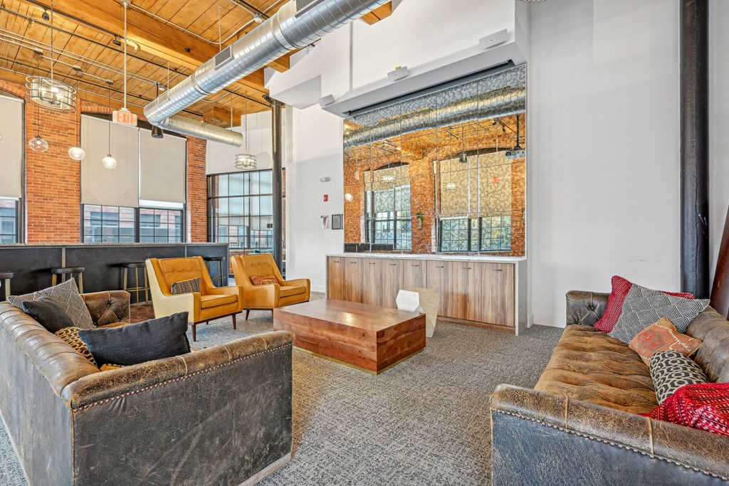 a living room with couches and chairs and a table at Riverwalk Apartments, Lawrence, MA