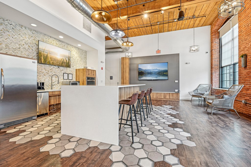 a kitchen with a white island and bar stools at Riverwalk Apartments, Lawrence, MA