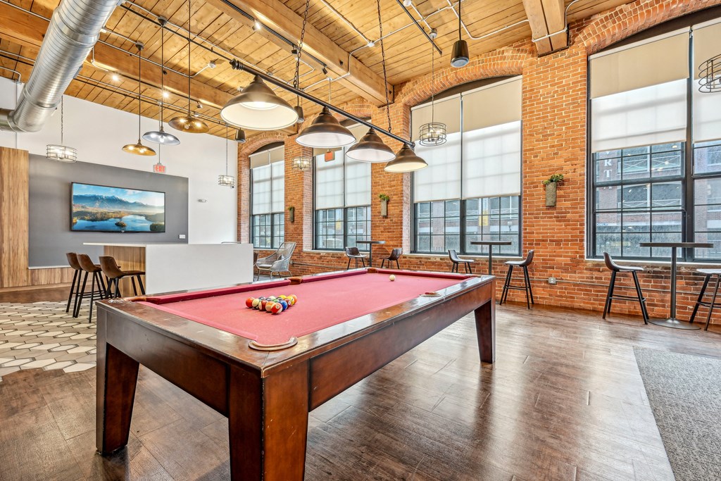a pool table in an office space with a red pool table at Riverwalk Apartments, Lawrence, MA