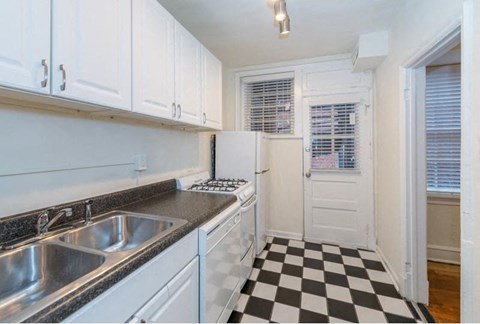 a kitchen with a checkered floor and white cabinets
