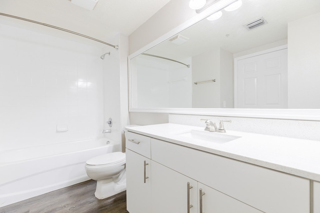 a bathroom with white cabinets and a white toilet at Heritage Bay, Jensen Beach, FL