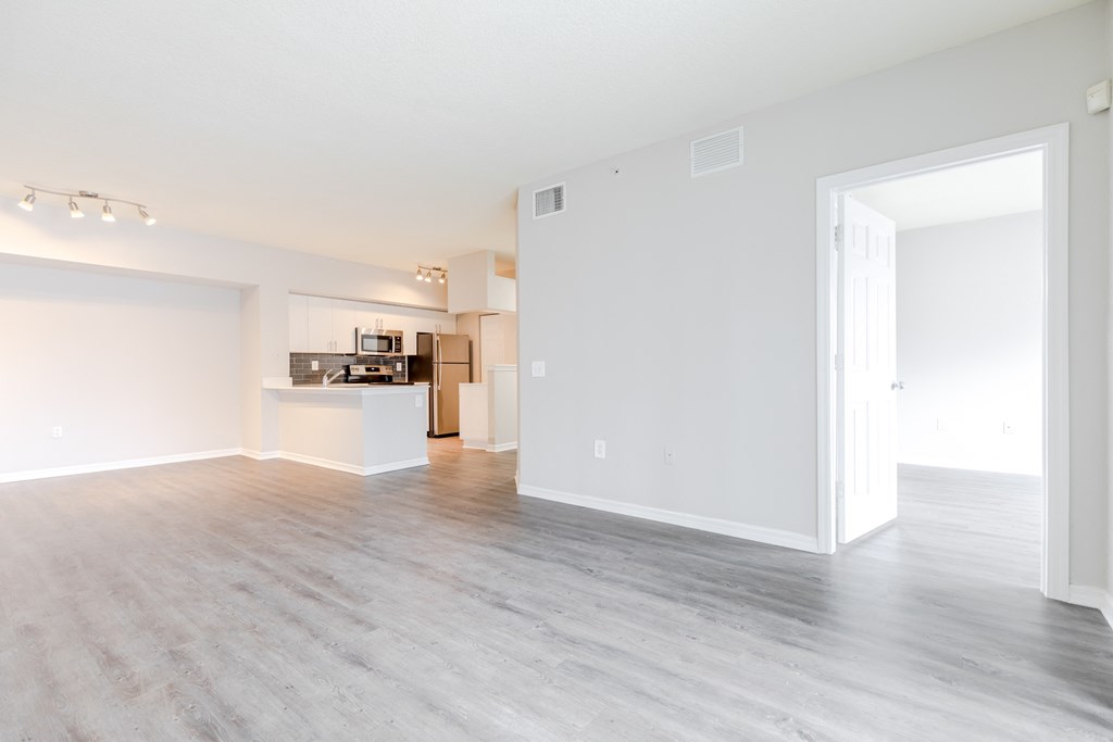 an empty living room with a kitchen in the background at Heritage Bay, Jensen Beach, FL 34957