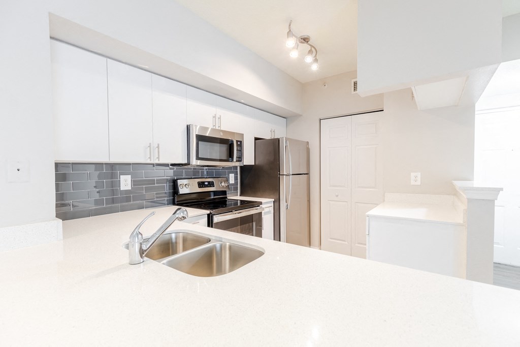 a kitchen with white countertops and stainless steel appliances at Heritage Bay, Florida, 34957