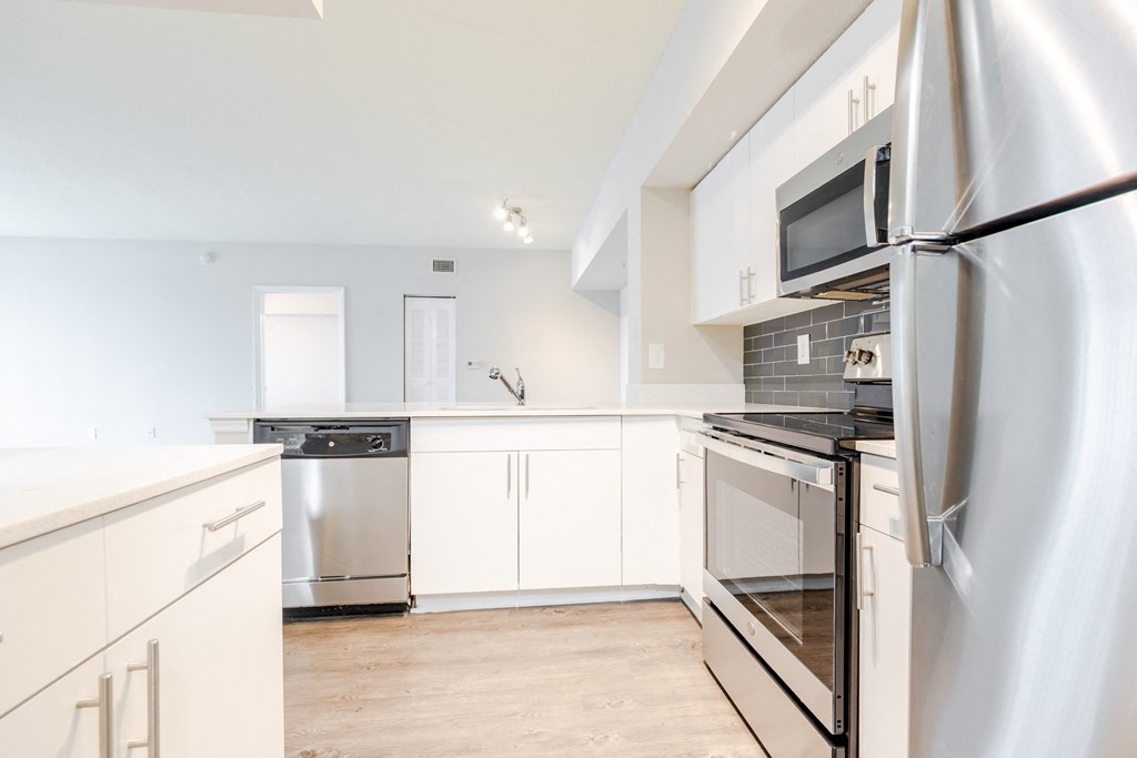 a kitchen with white cabinets and stainless steel appliances at Heritage Bay, Florida, 34957