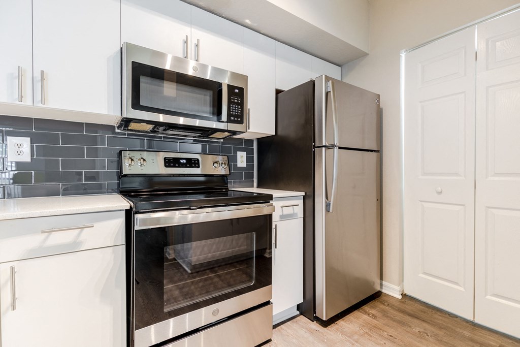 a kitchen with white cabinets and stainless steel appliances at Heritage Bay, Jensen Beach, FL