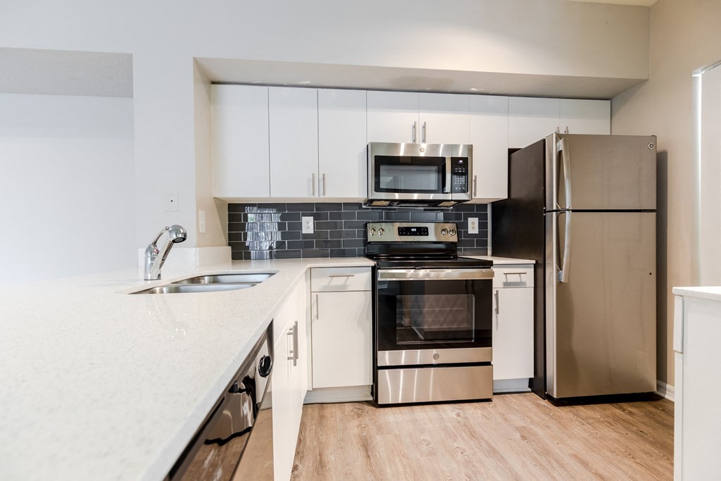 a kitchen with white cabinets and stainless steel appliances at Heritage Bay, Jensen Beach, 34957
