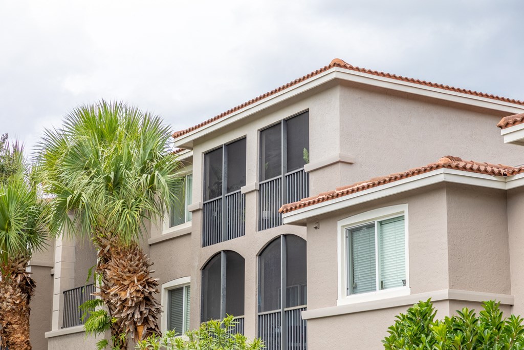 a condo building with a palm tree in front of it at Heritage Bay, Jensen Beach, 34957