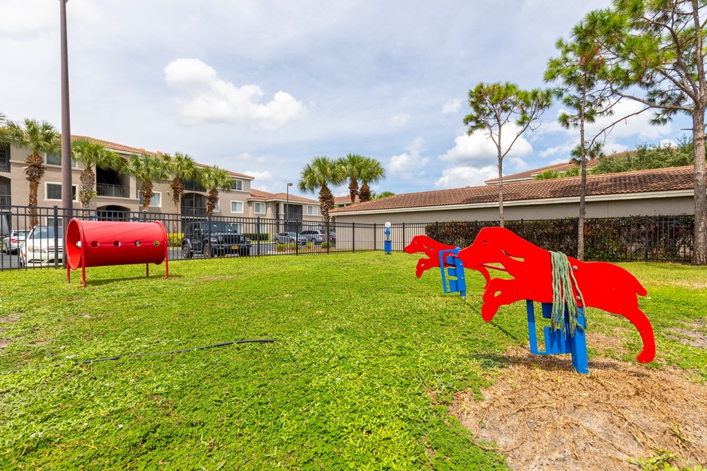 a playground with a red dog and a blue dog on a grassy field at Heritage Bay, Jensen Beach, 34957