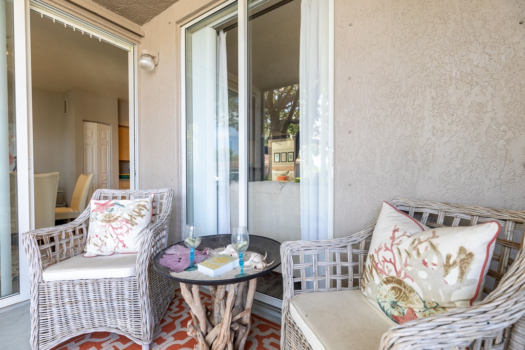 a patio with two wicker chairs and a small table at Heritage Bay, Florida