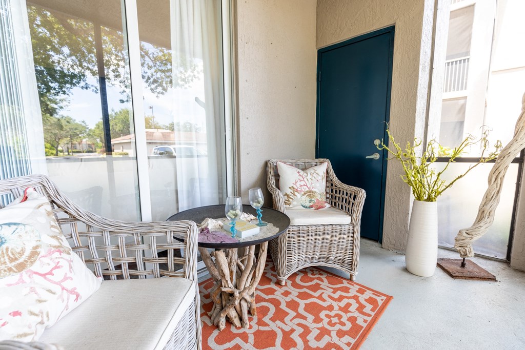a patio with two chairs and a table at Heritage Bay, Jensen Beach, FL