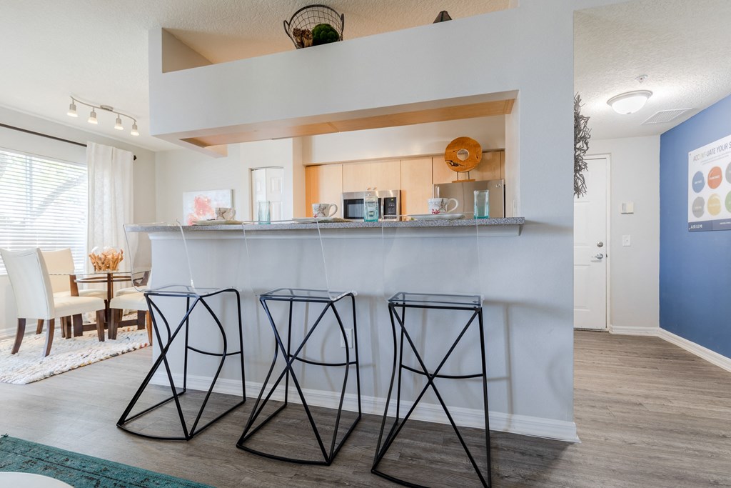 a kitchen with a bar and a dining room in the background at Heritage Bay, Jensen Beach, FL