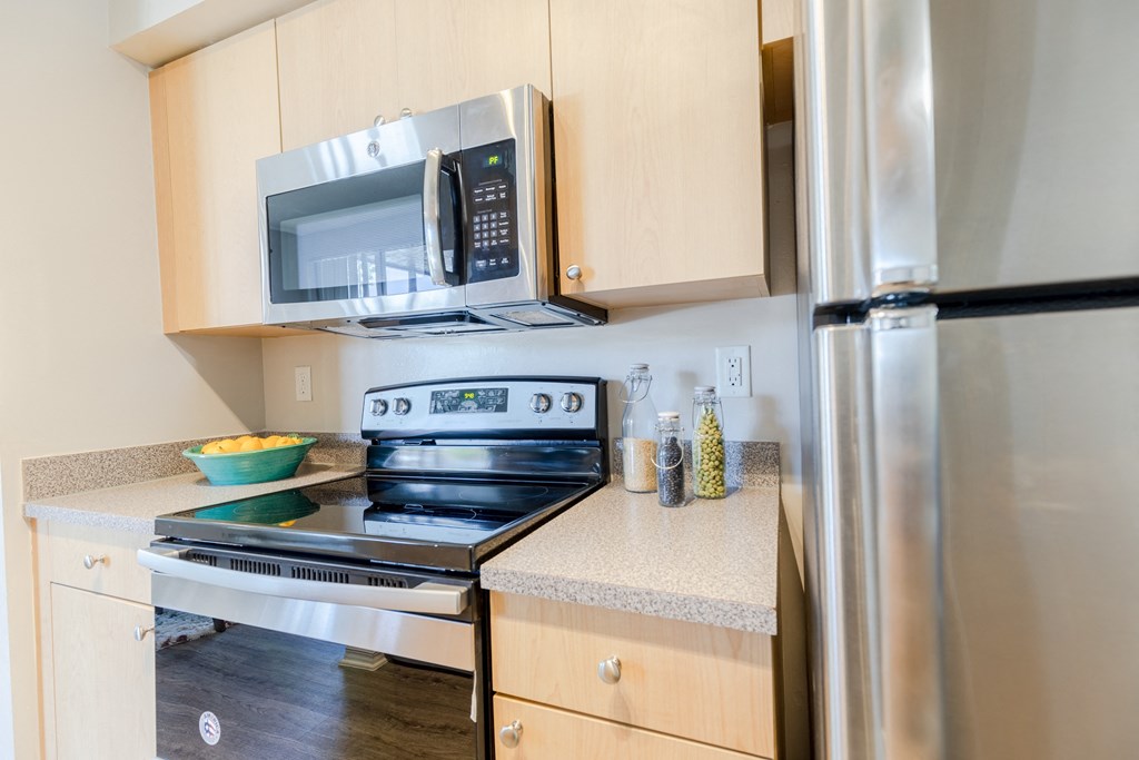a kitchen with wooden cabinets and stainless steel appliances at Heritage Bay, Jensen Beach, 34957