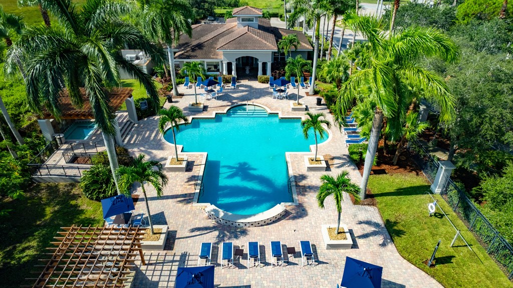 a large swimming pool with a house in the background at Heritage Bay, Jensen Beach, FL 34957