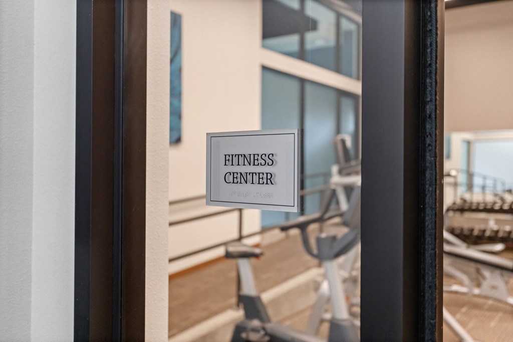 A sign that says Fitness Center is hanging on a wall.