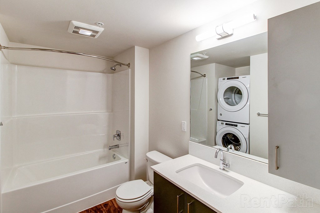 a bathroom with a toilet sink and a washer and dryer