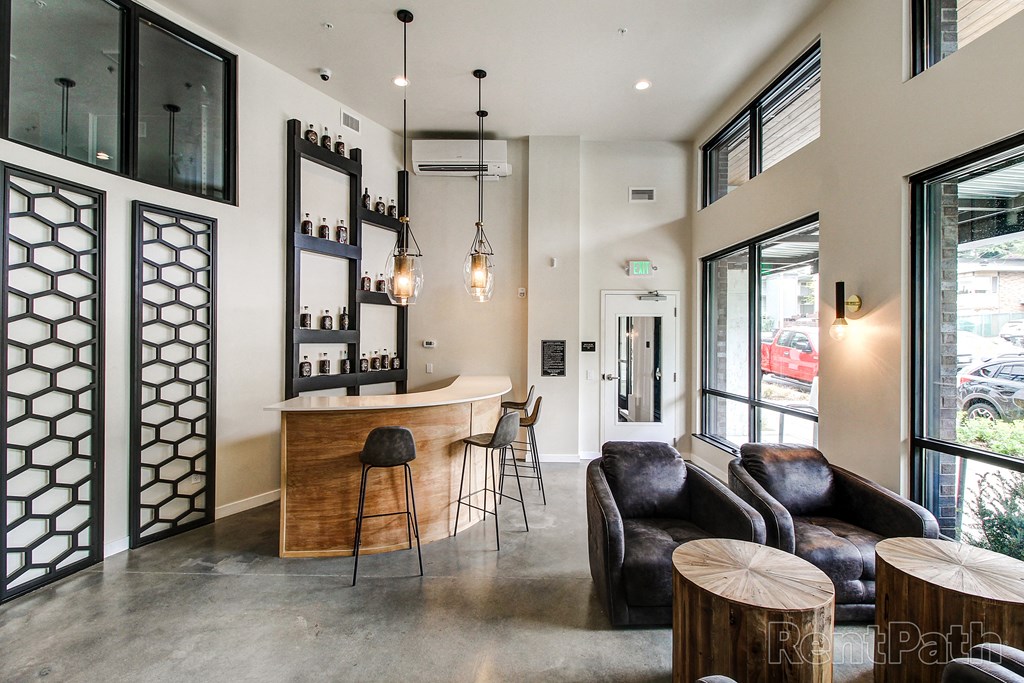 a tasting room with a bar and couches and chairs