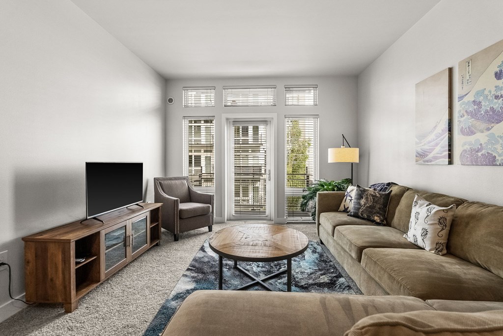 A living room with a brown couch, a wooden entertainment center, and a coffee table.