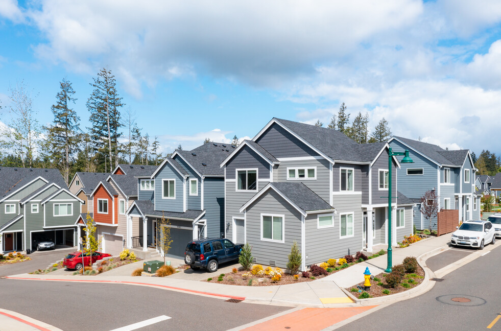 a row of houses with cars parked in front of them