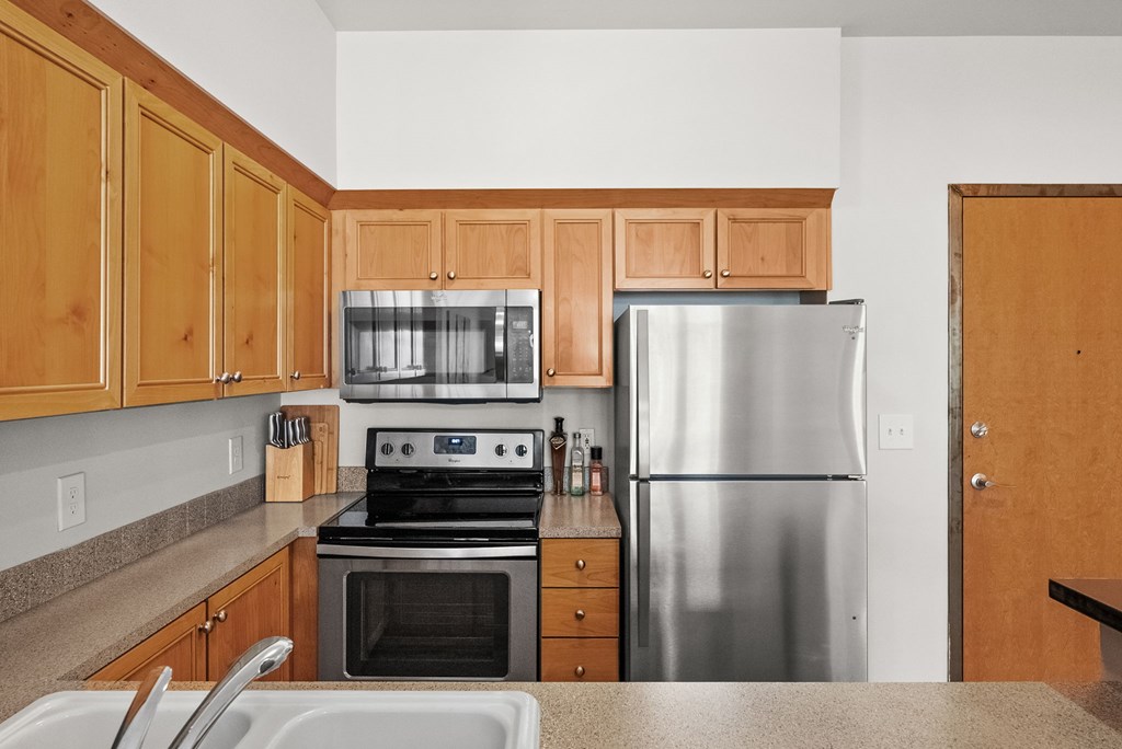 A kitchen with wooden cabinets and stainless steel appliances.