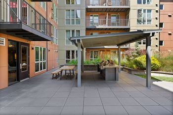 A patio with a table and chairs is surrounded by buildings.
