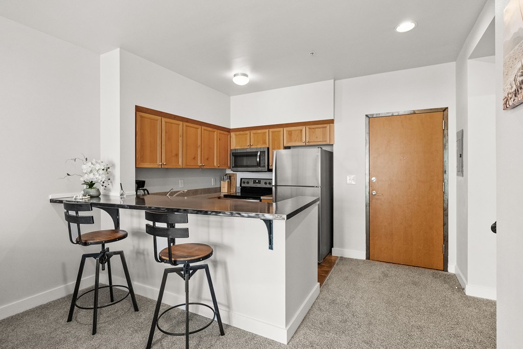 A kitchen with a bar stool and a counter.