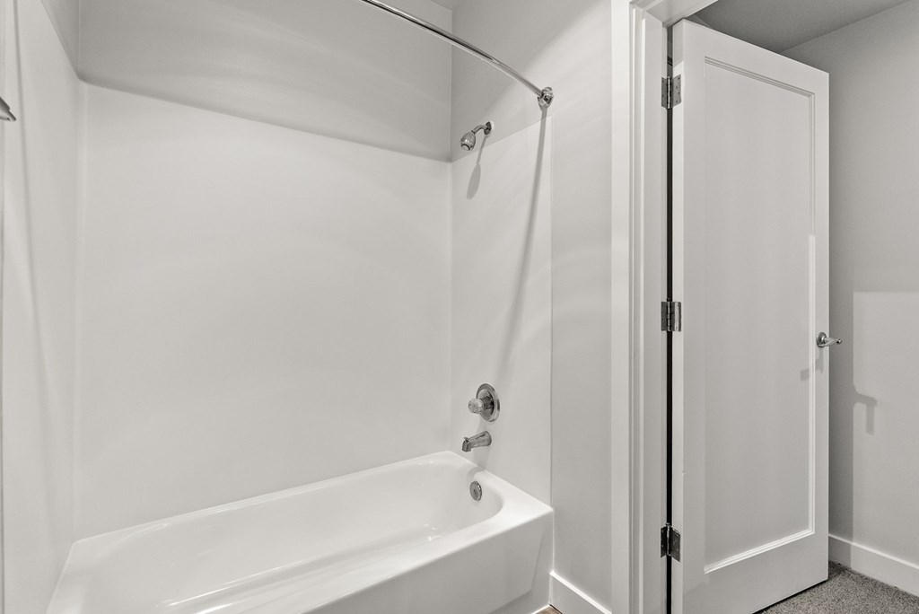 A white bathroom with a tub and shower.