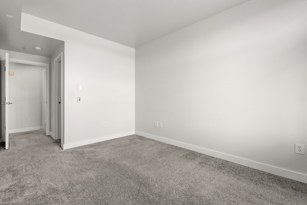 A room with a carpeted floor and white walls.