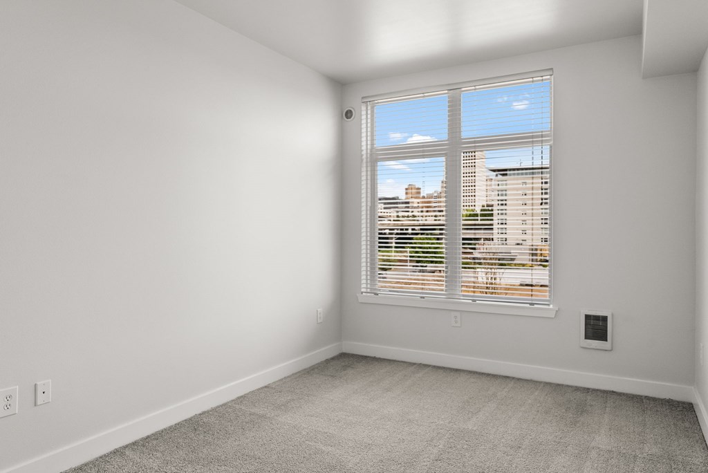 A room with a large window overlooking a cityscape.