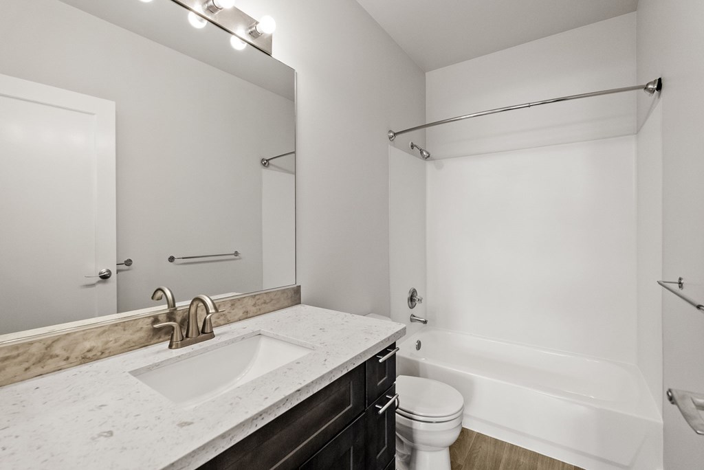A white bathroom with a marble counter top.