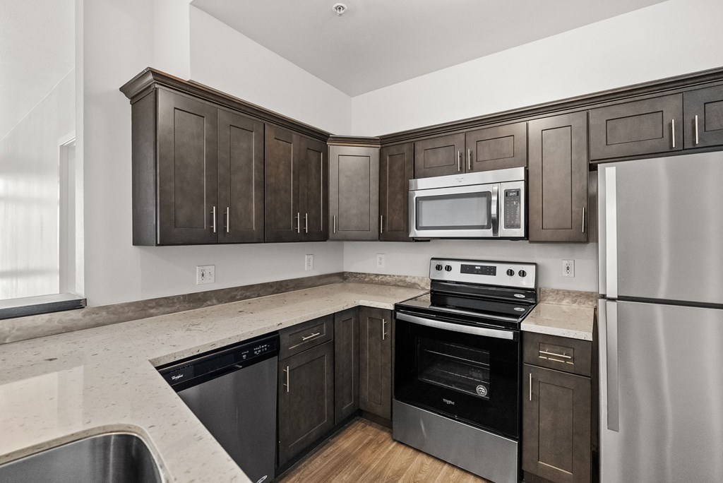 A kitchen with dark wood cabinets and stainless steel appliances.