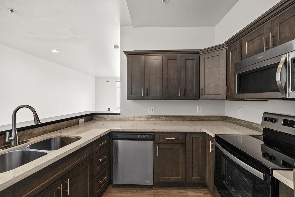 A kitchen with dark wood cabinets and stainless steel appliances.