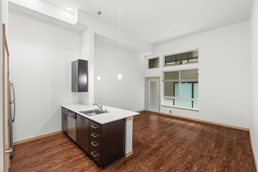 A kitchen with a wooden floor and white walls.