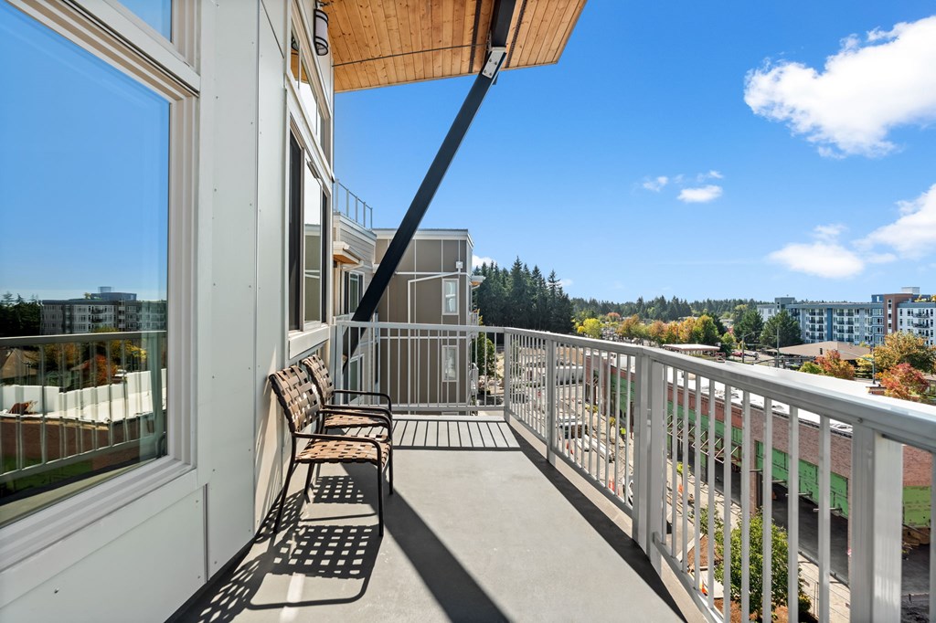 A balcony with a metal railing and a black metal bench.