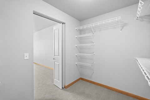 an empty bedroom with a closet and a door to the bathroom