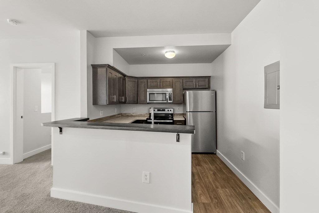 A kitchen with a white countertop and a stainless steel refrigerator.
