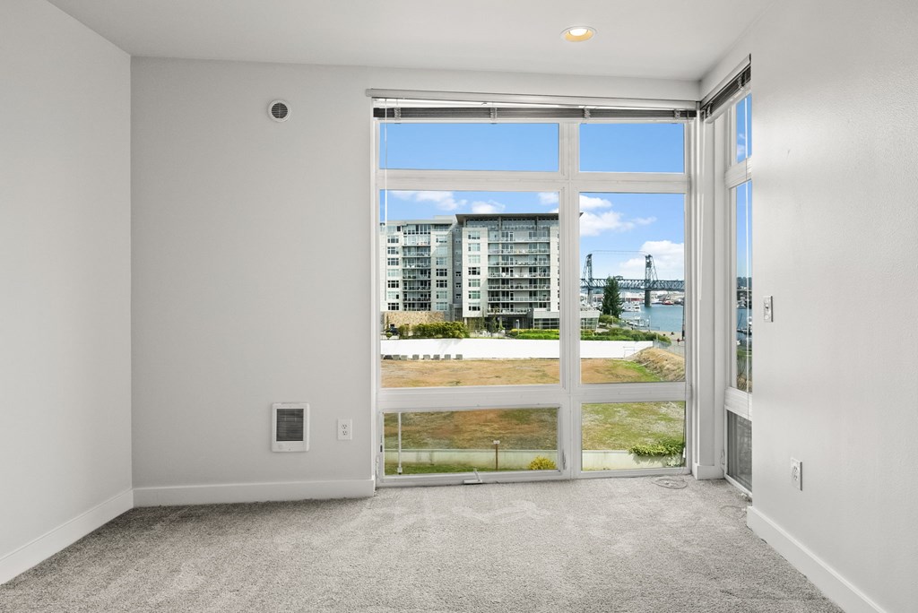 A room with a large window overlooking a beach.