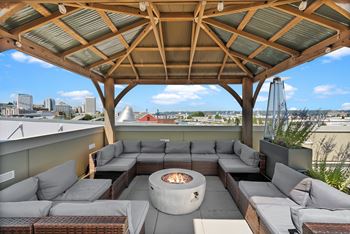 A patio with a fire pit and couches.