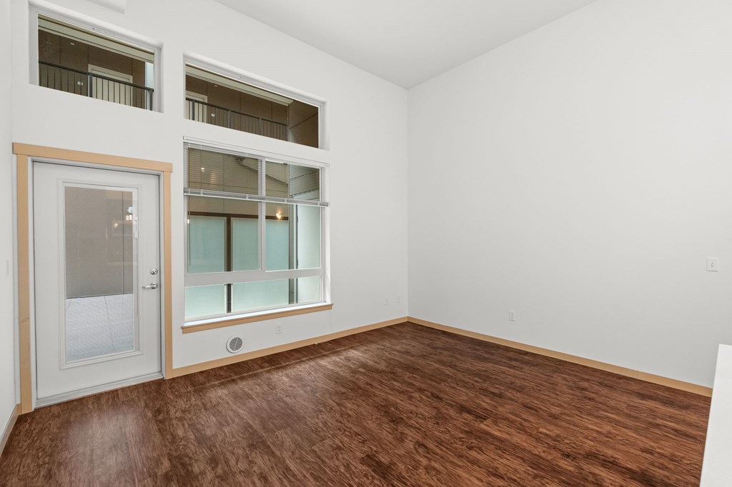 A room with a brown floor and white walls.