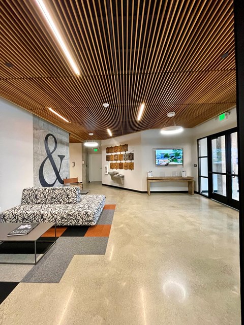A modern waiting room with a wooden ceiling and a couch.