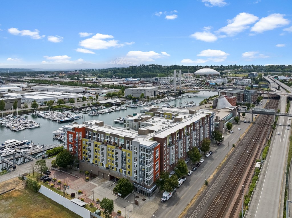 A view of a city with a large building in the foreground and a bridge in the background.