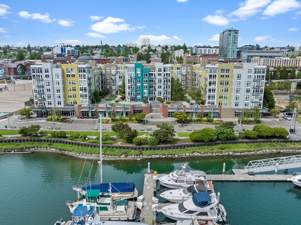 A marina with boats docked and buildings in the background.